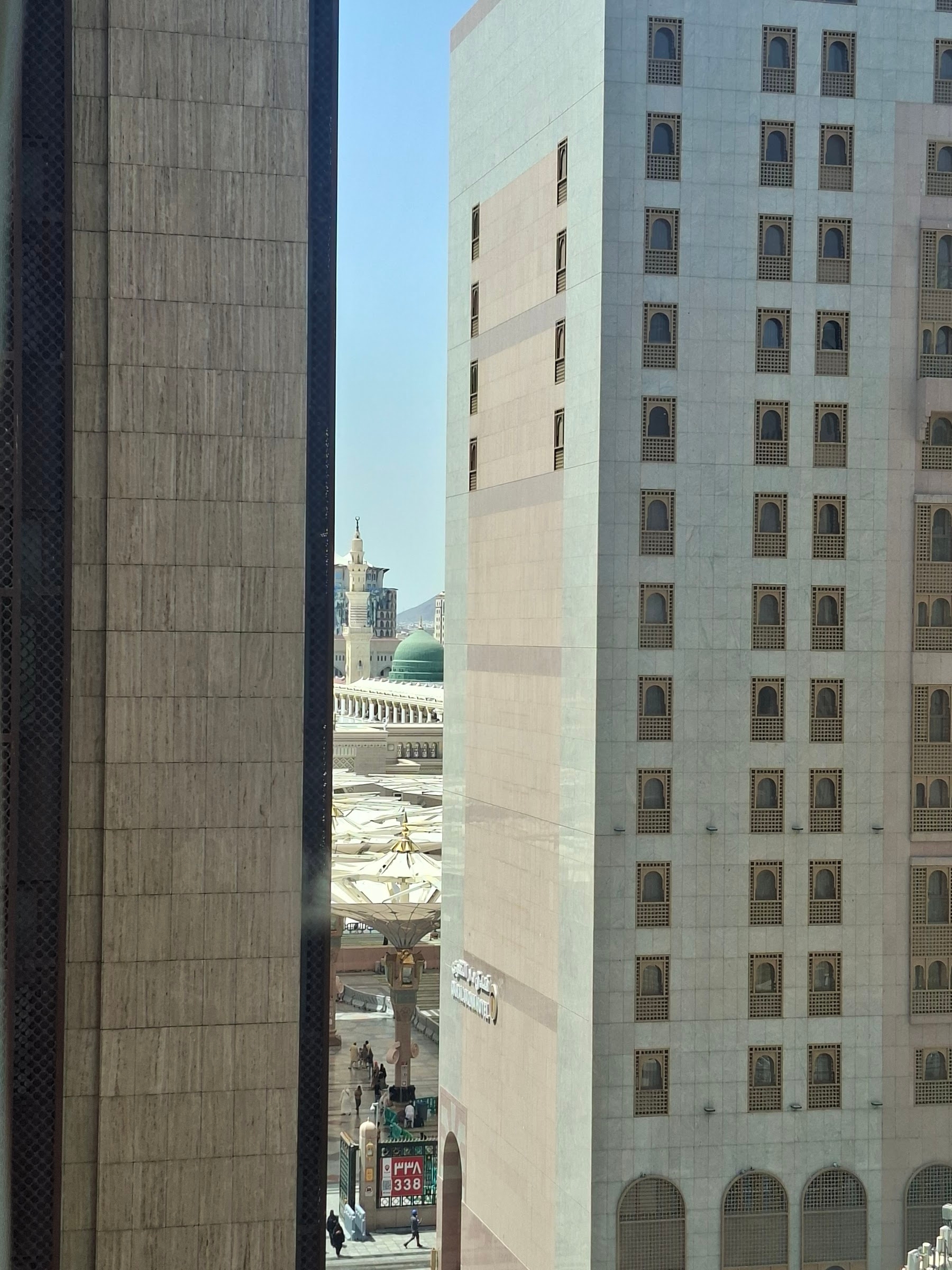 A glimpse of the Prophet's Mosque between the buildings, from a room's window