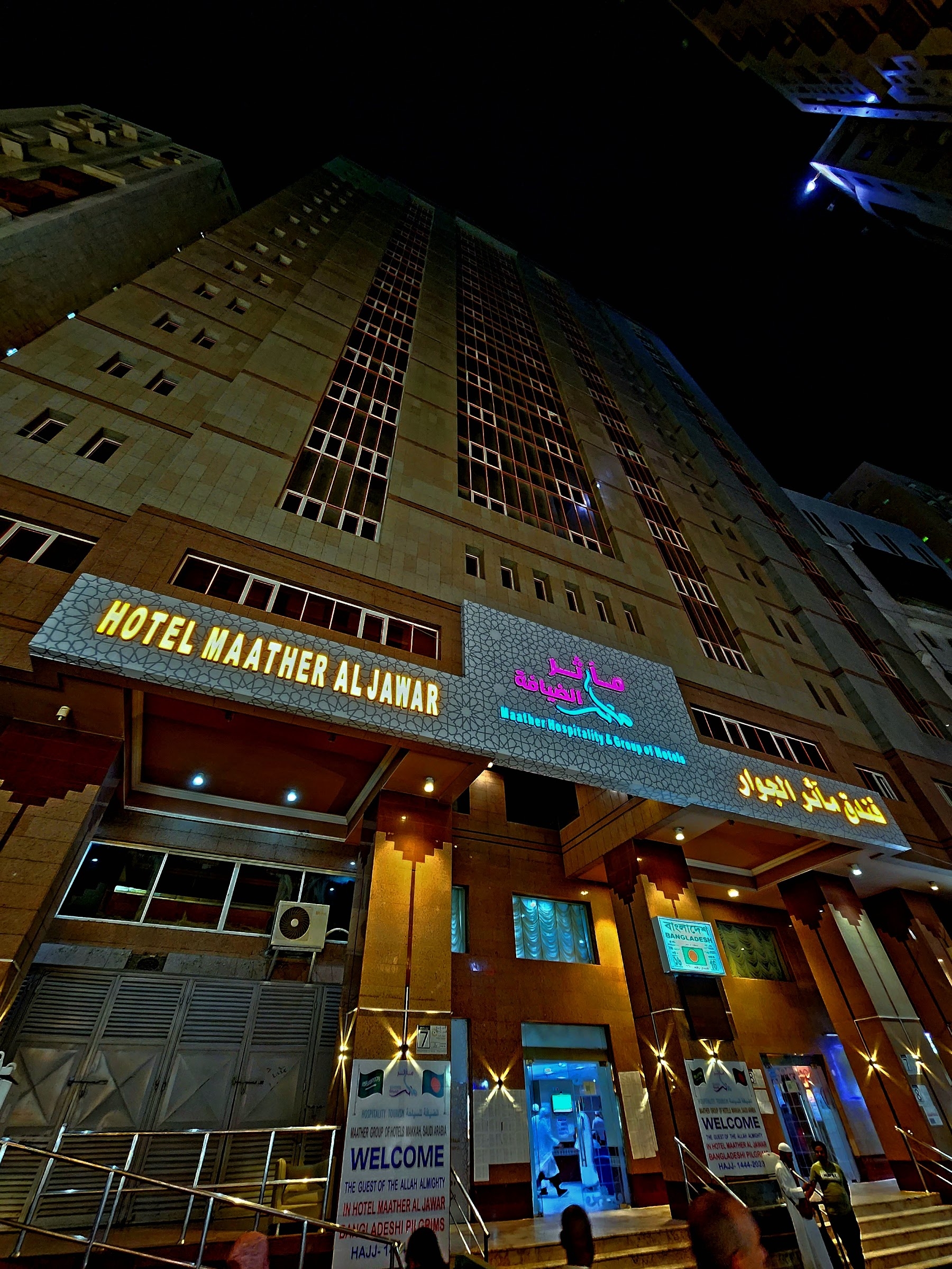 Pintu masuk dan papan nama hotel pada malam hari